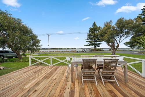 a wooden deck with a table and chairs on it at Percys Place- Waterfront pet and family friendly in Goolwa