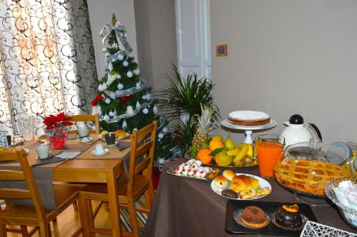 a table with food and a christmas tree in a room at Alba Camere in Palermo