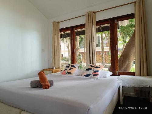 two beds in a bedroom with a large window at Horizon Resort in Ko Samed