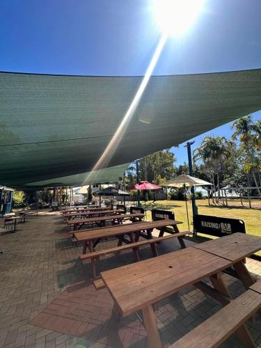 a group of picnic tables under a large umbrella at Bushland Beach Tavern in Townsville