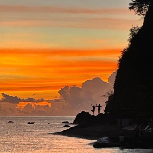a painting of a cross on the beach at sunset at Rainbow Heights Apartment, Soufriere in Soufrière