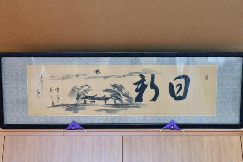 a framed picture on top of a wooden cabinet at Ubusuna no Sato TOMIMOTO in Ando