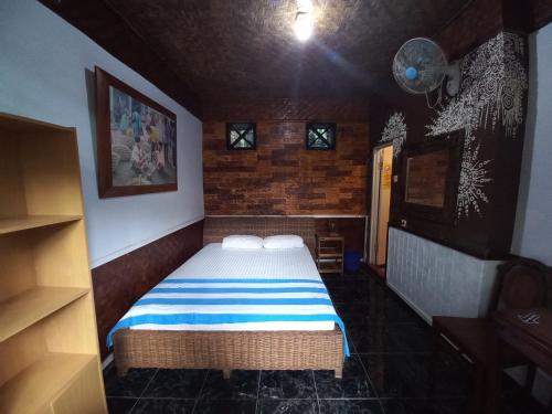 a small bedroom with a bed in a room at Mini Tiga Homestay in Pangandaran