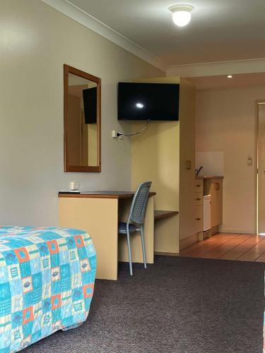 a hotel room with a bed and a desk with a mirror at Bushland Beach Tavern in Townsville