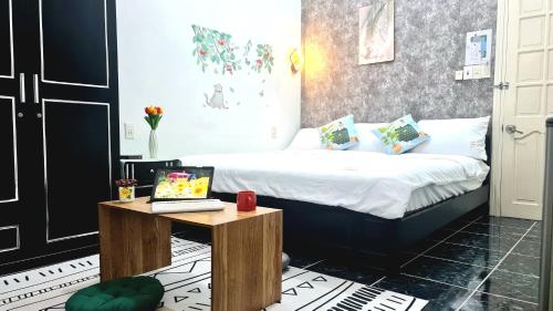 a bedroom with a bed with a laptop on a table at Minh Trang Villa Hoi An -BBQ Garden in Hoi An