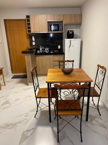 a kitchen with a table and two chairs and a kitchen with a refrigerator at flat 107 Morubixaba in Iriri