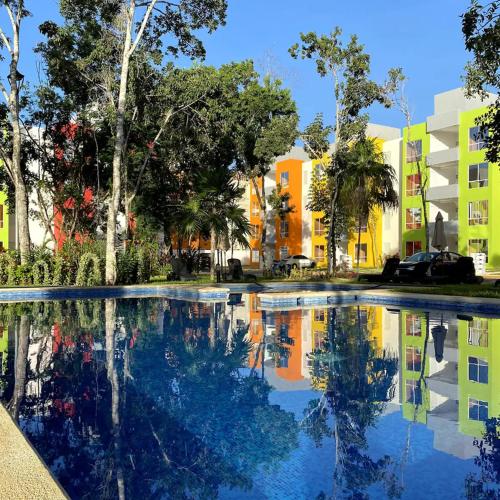 a swimming pool in front of a building at Bonito departamento en privada con alberca in Cancún