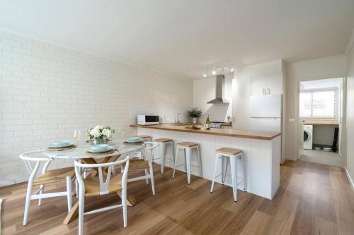 a kitchen with a table and stools in a room at 50m Walk to River , Pet Friendly, Spacious in Ocean Grove