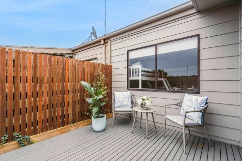 a wooden deck with two chairs and a table at 50m Walk to River , Pet Friendly, Spacious in Ocean Grove