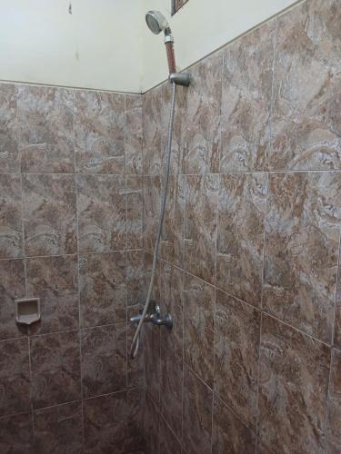 a shower in a bathroom with a tile wall at Danny juljol homestay in Huu