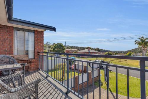 a balcony of a house with a table and chairs at Harbour Lights - townside with a pool in Merimbula