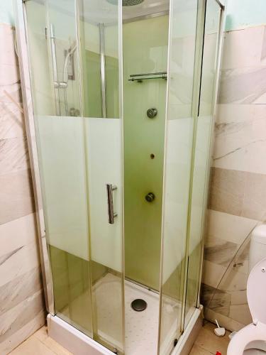 a shower stall in a bathroom with a toilet at Villa Amina in Ouagadougou