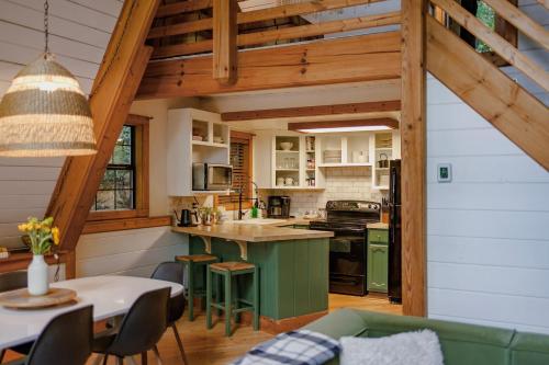 a kitchen with a green island in a house at Big Mountain View! Downtown Gatlinburg Chalet Village! Hot Tub! Fan Favorite! AFrame Dreams! Magazine-Featured! Stunning Interiors! Little Green Cabin in Gatlinburg