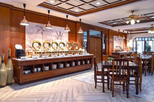 een restaurant met tafels en stoelen en een bar met vazen bij Tony Resort in Patong Beach