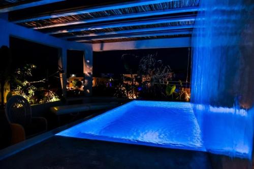 a swimming pool in a room with blue lights at Aruma Villa Boutique Isla Mujeres with beach club access included in Isla Mujeres