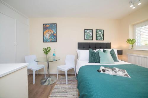 a bedroom with a bed and a table and chairs at Wilson House - Camden in London