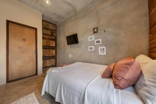a bedroom with a white bed and a television at Aruma Villa Boutique Isla Mujeres with beach club access included in Isla Mujeres
