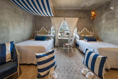 a bedroom with two beds and a chair and a table at Aruma Villa Boutique Isla Mujeres with beach club access included in Isla Mujeres