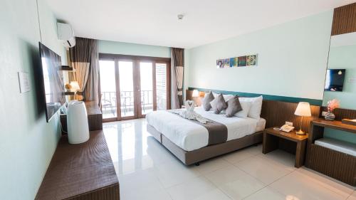 a hotel room with a bed and a balcony at Siam Triangle Hotel Chiang Sean in Chiang Saen