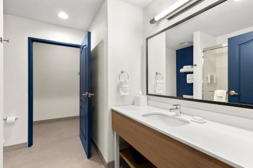a bathroom with a sink and a mirror at Spark By Hilton Missouri City in Missouri City