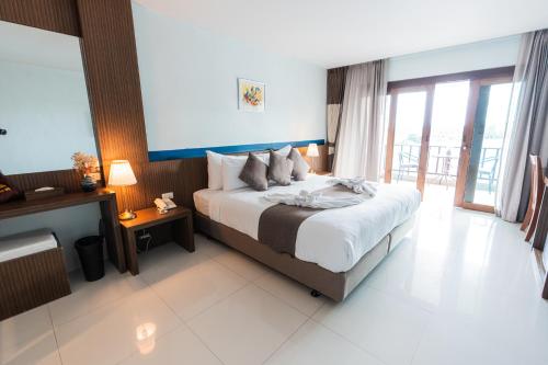 a bedroom with a large bed and a balcony at Siam Triangle Hotel Chiang Sean in Chiang Saen
