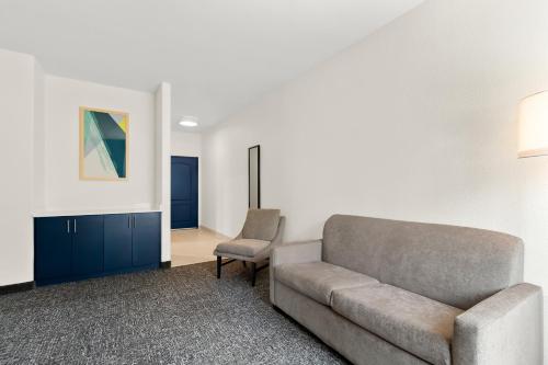 a living room with a couch and a chair at Spark By Hilton Missouri City in Missouri City