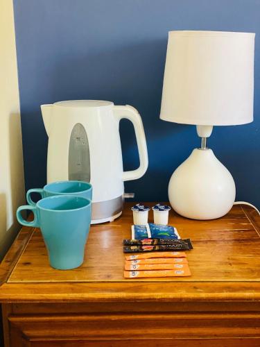 a table with a lamp and cups on a dresser at Boardrider Backpackers and Budget Motel in Sydney