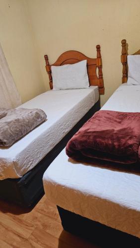 two beds sitting next to each other in a room at Goodlife Guest house in mafikeng in Mahikeng