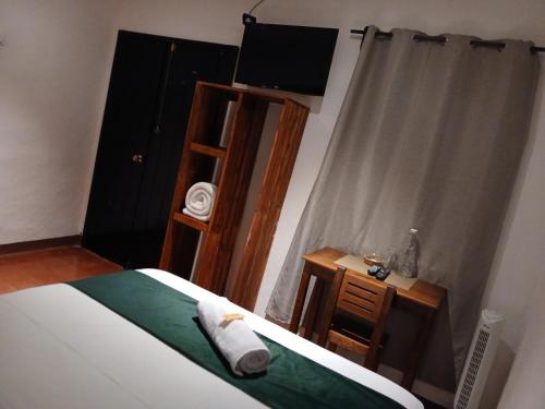 a bedroom with a bed and a ladder and a television at Hotel La Xinca in Antigua Guatemala