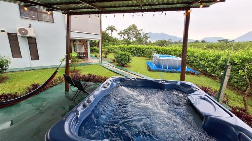 a hot tub in the backyard of a house at Arenal Nephelium Country Home, Refugio rural con piscina, jacuzzi y balcón con hermosas vistas al Volcán Arenal, en una finca privada in Fortuna