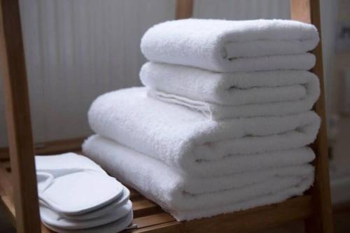 a stack of white towels on a shelf in a bathroom at Wilson House - Camden in London
