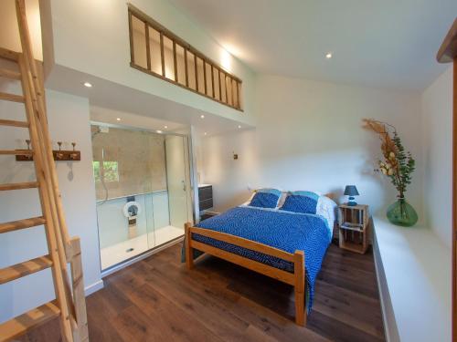 a bedroom with a bed with a blue comforter at Gîte spacieux à Happonvilliers avec jardin privatif, accueil jusqu'à 14 personnes, animaux admis - FR-1-581-139 in Happonvilliers