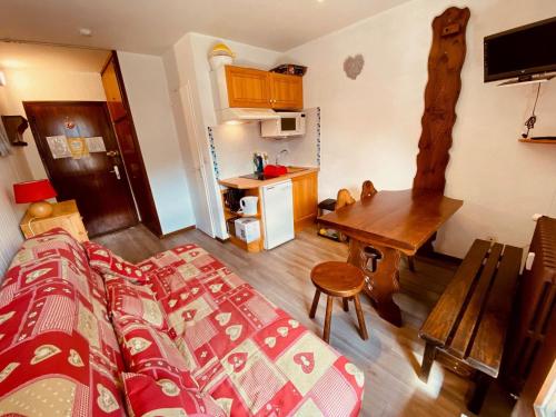 une chambre avec un lit et un bureau et une cuisine dans l'établissement Petit studio à 250 m des pistes avec balcon au centre de La Clusaz - FR-1-459-233, à La Clusaz