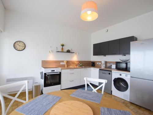 - une cuisine avec des appareils blancs, une table et des chaises dans l'établissement Bel appartement proche thermes avec balcon et animaux admis - FR-1-498-106, à Évian-les-Bains
