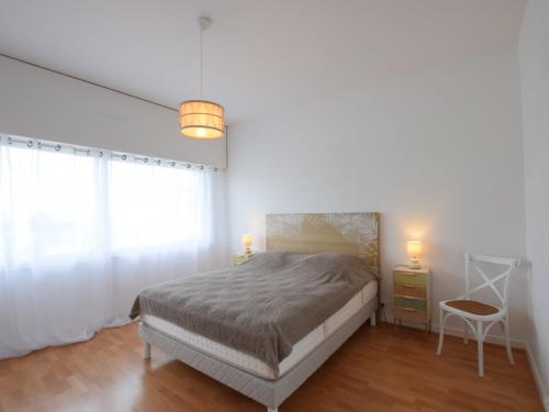 une chambre avec un lit, une table et une chaise dans l'établissement Bel appartement proche thermes avec balcon et animaux admis - FR-1-498-106, à Évian-les-Bains