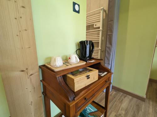 une table en bois avec un four micro-ondes. dans l'établissement Chambre familiale climatisée avec accès jardin - FR-1-589-663, à Rehaupal