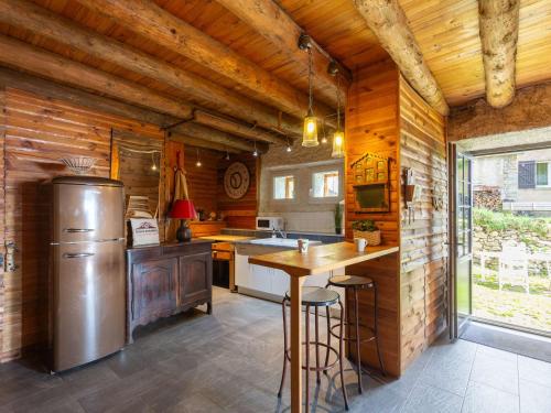Il comprend une cuisine avec un réfrigérateur et un mur en bois. dans l'établissement Grange authentique à Saint-Lary-Soulan - 5 couchages, cheminée, casier à skis - FR-1-296-502, à Saint-Lary-Soulan