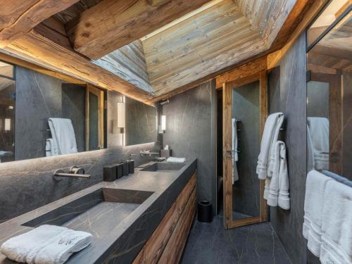 a bathroom with two sinks and a wooden ceiling at Chalet de Luxe avec Piscine, Sauna, Salle de Sport et Cinéma - FR-1-569-194 in Megève