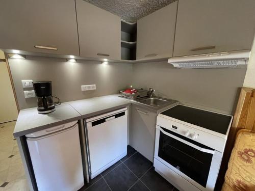 une petite cuisine avec un évier et une cuisinière dans l'établissement Duplex moderne avec balcon, proche pistes, 2 chambres - FR-1-787-77, à Laveissière