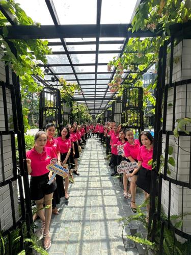 a group of girls in pink shirts in a greenhouse at X Hotel Thái Nguyên in Thái Nguyên