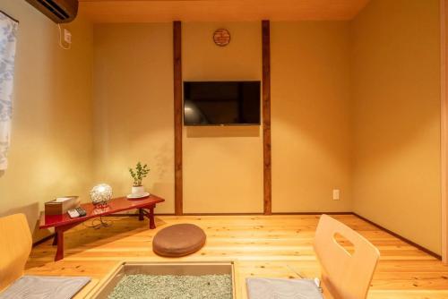 a living room with yellow walls and a table and chairs at 三十三Tuchi in Kyoto