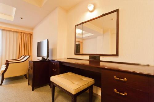 a hotel room with a desk with a mirror and a chair at Morioka Grand Hotel Annex in Morioka
