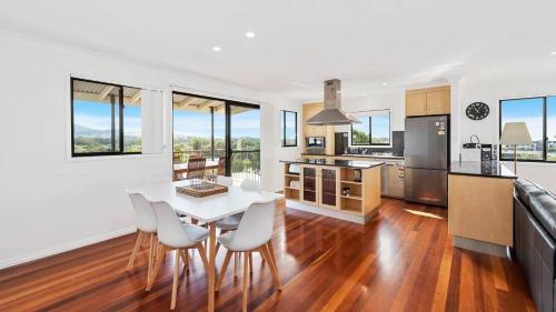 Una cocina y un comedor con mesa y sillas. en Jetty Escape Townhouse - Cafes, Parks, Beach, en Coffs Harbour