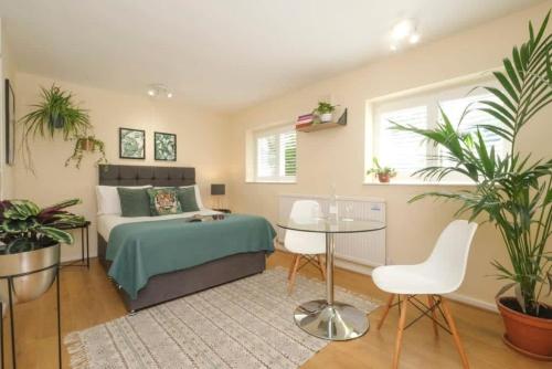 a bedroom with a bed and a table and plants at Wilson House - Camden in London