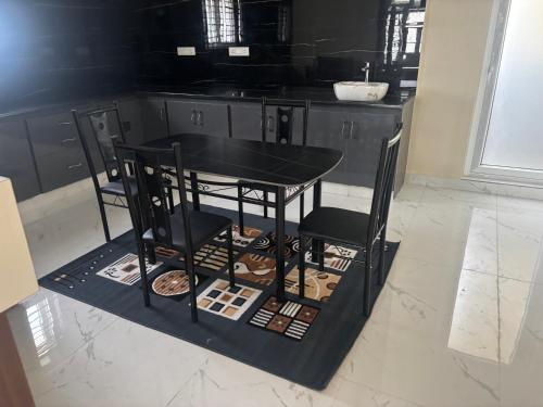a black table and chairs in a kitchen at Nest Inn Homestay in Tirupati