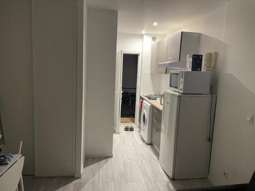 une petite cuisine avec un réfrigérateur et un micro-ondes dans l'établissement studio a louer, à Épinay-sur-Seine
