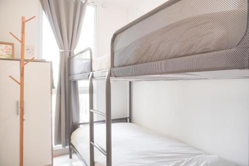 RawalembangGood Price and Nice 2BR Tokyo Riverside PIK 2 Apartment By Travelio的配有梯子的塔楼客房中的双层床