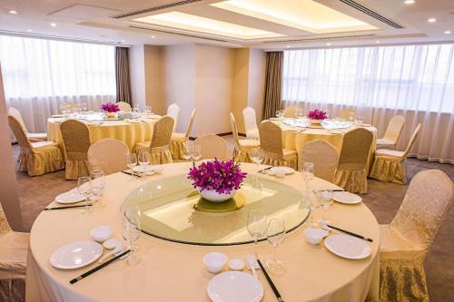 a conference room with tables and chairs with flowers on them at Deacon House Wuxi in Wuxi
