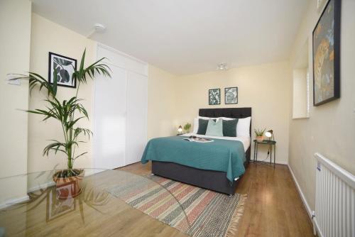 a bedroom with a bed and a potted plant at Wilson House - Camden in London