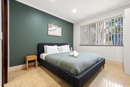 un dormitorio con una cama y una ventana en River Tree Chalet - Margaret River NEW, en Margaret River Town
